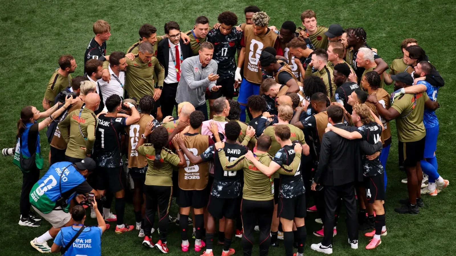 Jesse Marsch, Head Coach of Canada, speaks with his players in a huddle after the team's victory.