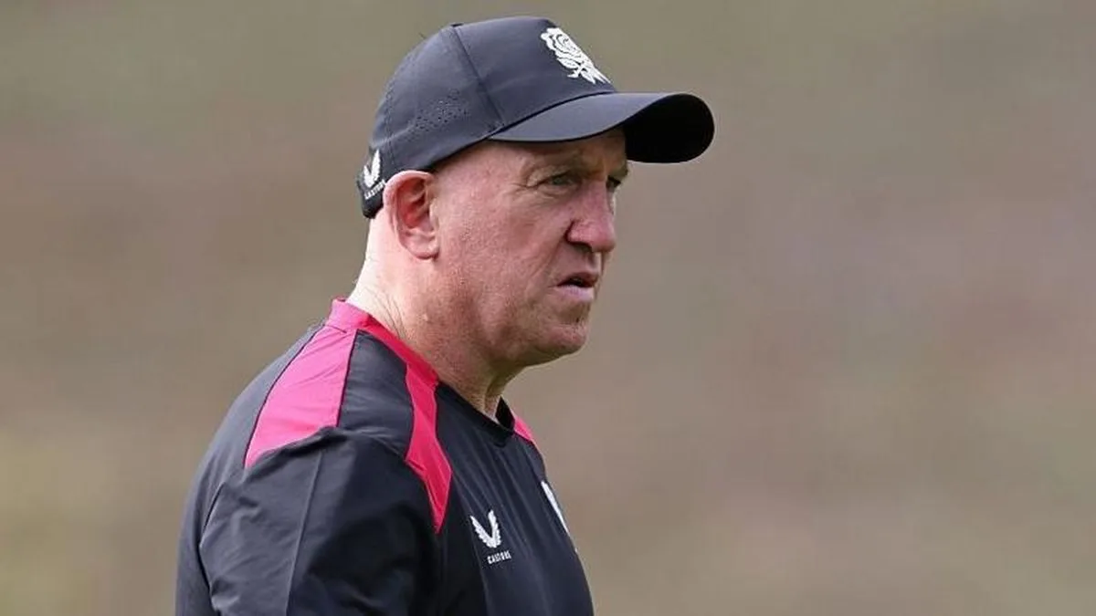 Shaun Edwards, wearing a black-and-red T-shirt and a black baseball cap, looks on during an England training session