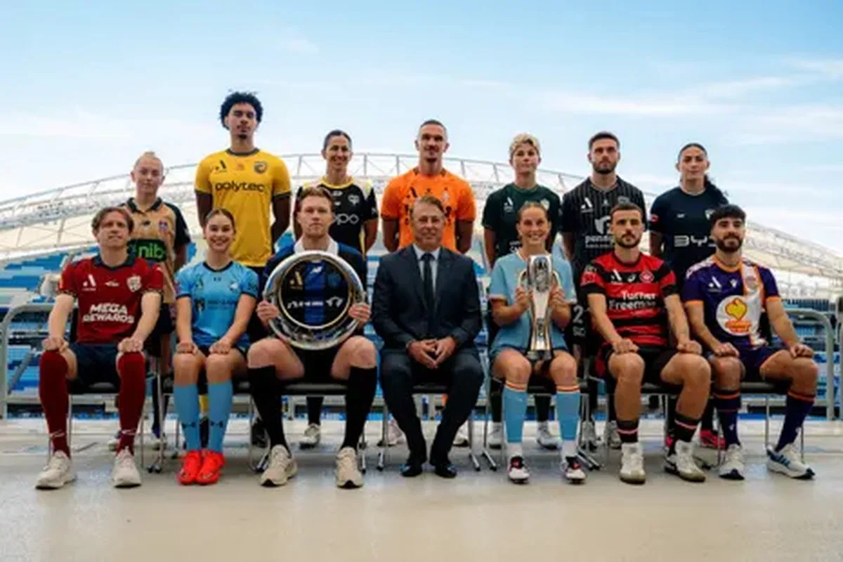 Players Craig Goodwin, Indiana Dos Santos, Sam Cosgrove, APL CEO Steve Rosich, Shelby McMahon, Nicolas Milanovic, Charbel Shamoon, Cass Davis, Diesel Herrington, Abby Erceg, Tom Aldred, Michelle Heyman, Callum Talbot and Claudia Bunge pose for a photograph