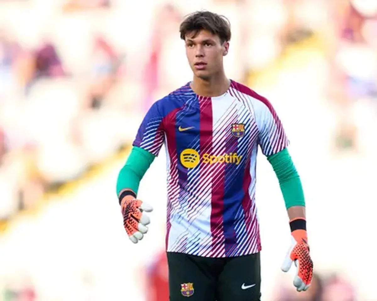 A young man in a multicolored football kit.