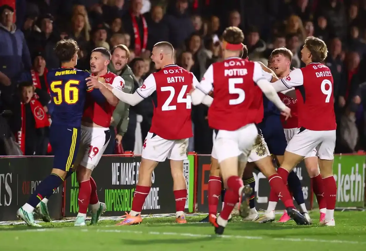 Max Dowman is surrounded by Fleetwood players after his red-card offence