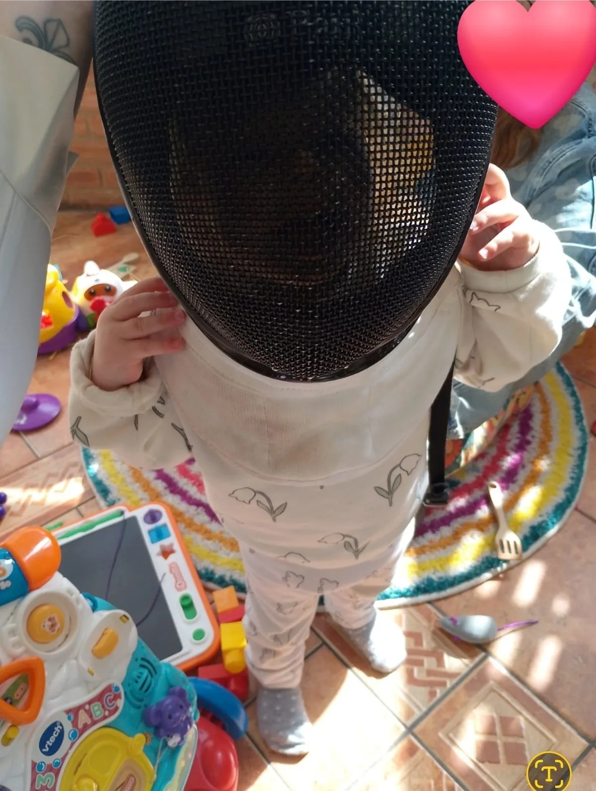 Daisy wearing her mums fencing mask