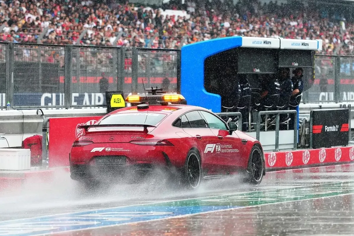 FIA Medical Car kicks up spray in the pit lane.