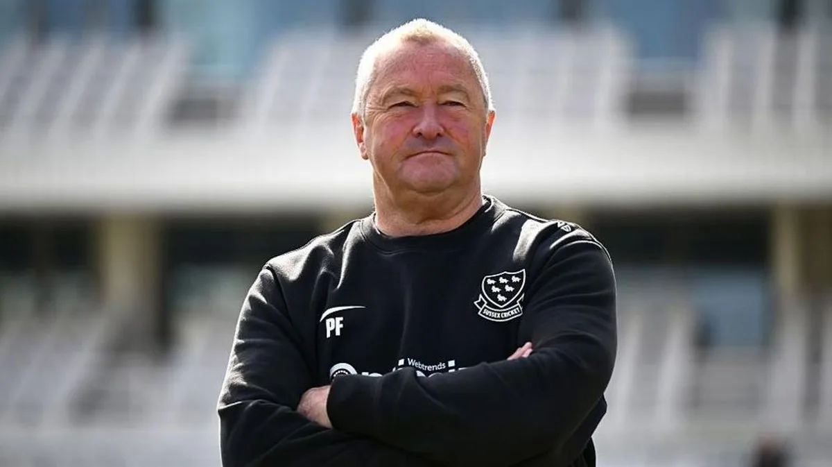 Paul Farbrace stands looking proudly, with his arms crossed, wearing Sussex black training top 