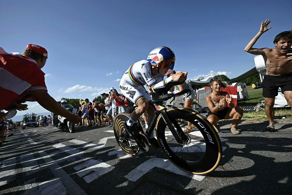 Evenepoel in the rainbow jersey time trialing past cheering fans