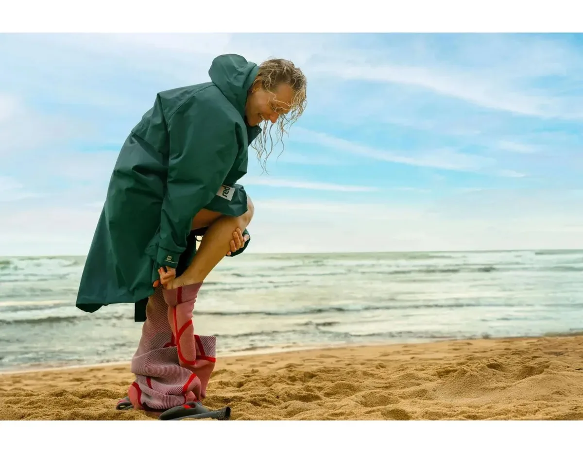 Woman changing in swim robe by sea